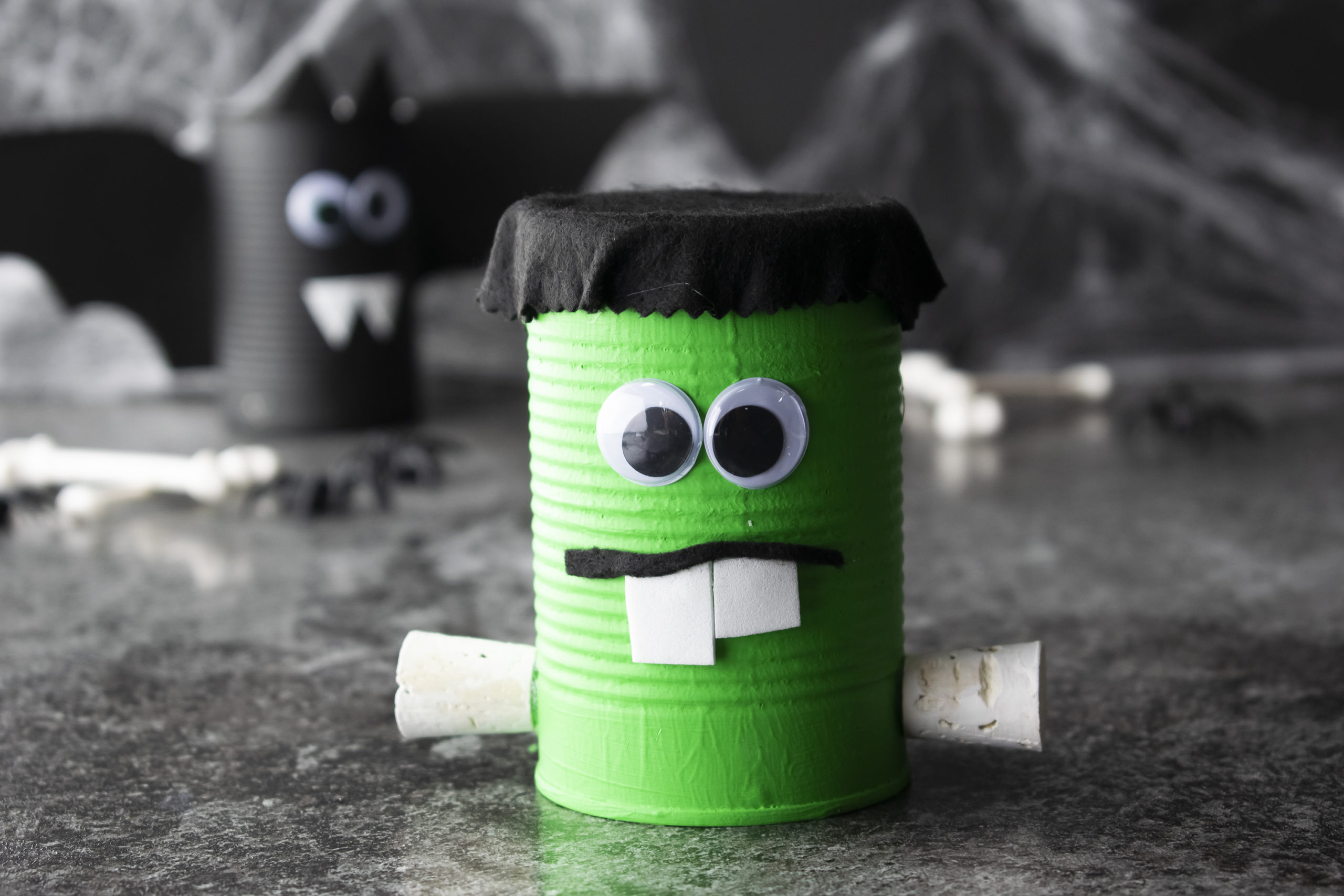 Easy-to-make “spooky cans” resembling a bat, Frankenstein and a mummy. Fun Halloween party activities for kids on mybergen.com.